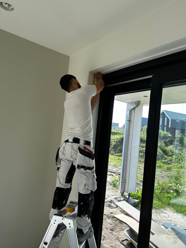 Vakman van HB Afbouw werkt aan een wand in een nieuwbouwwoning